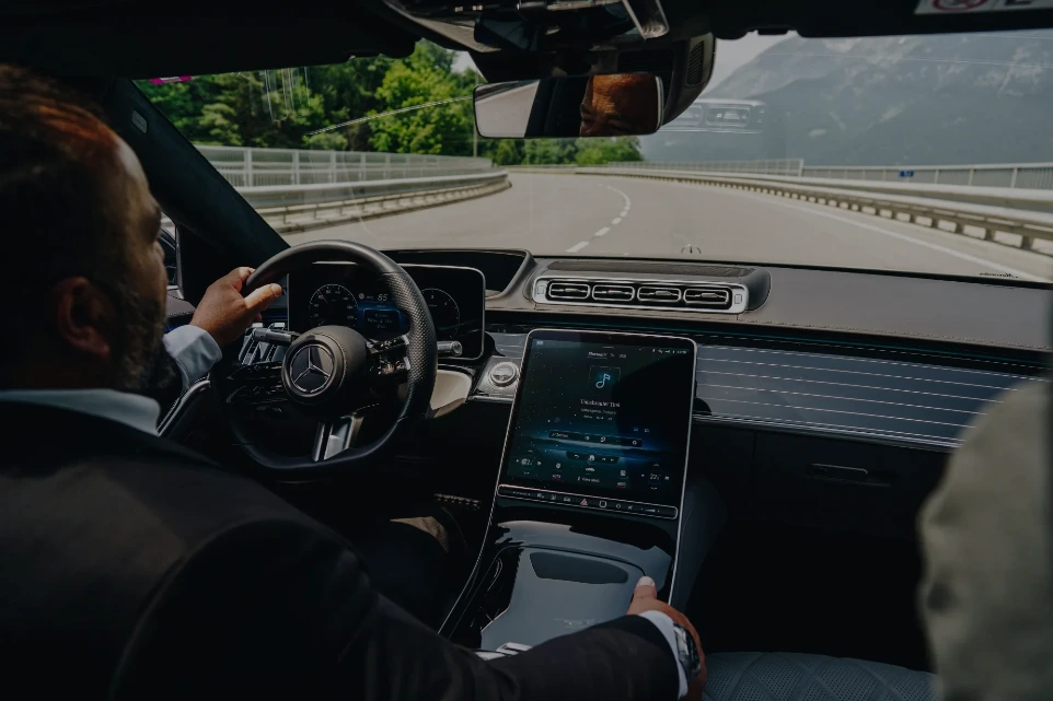 Chauffeur am Steuer einer Mercedes S-Klasse während einer Fahrt